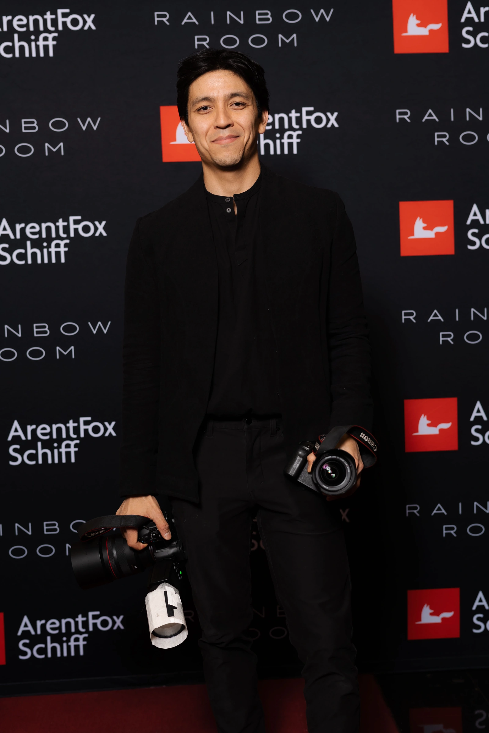 Alex Lee holding his cameras at an ArentFox Schiff event