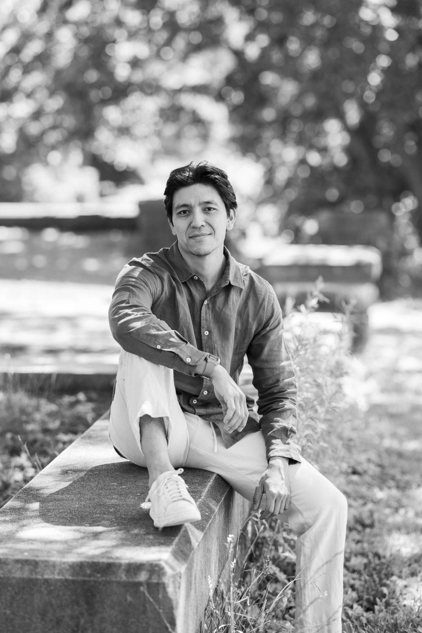 Alex Lee seated outdoors in a black-and-white portrait