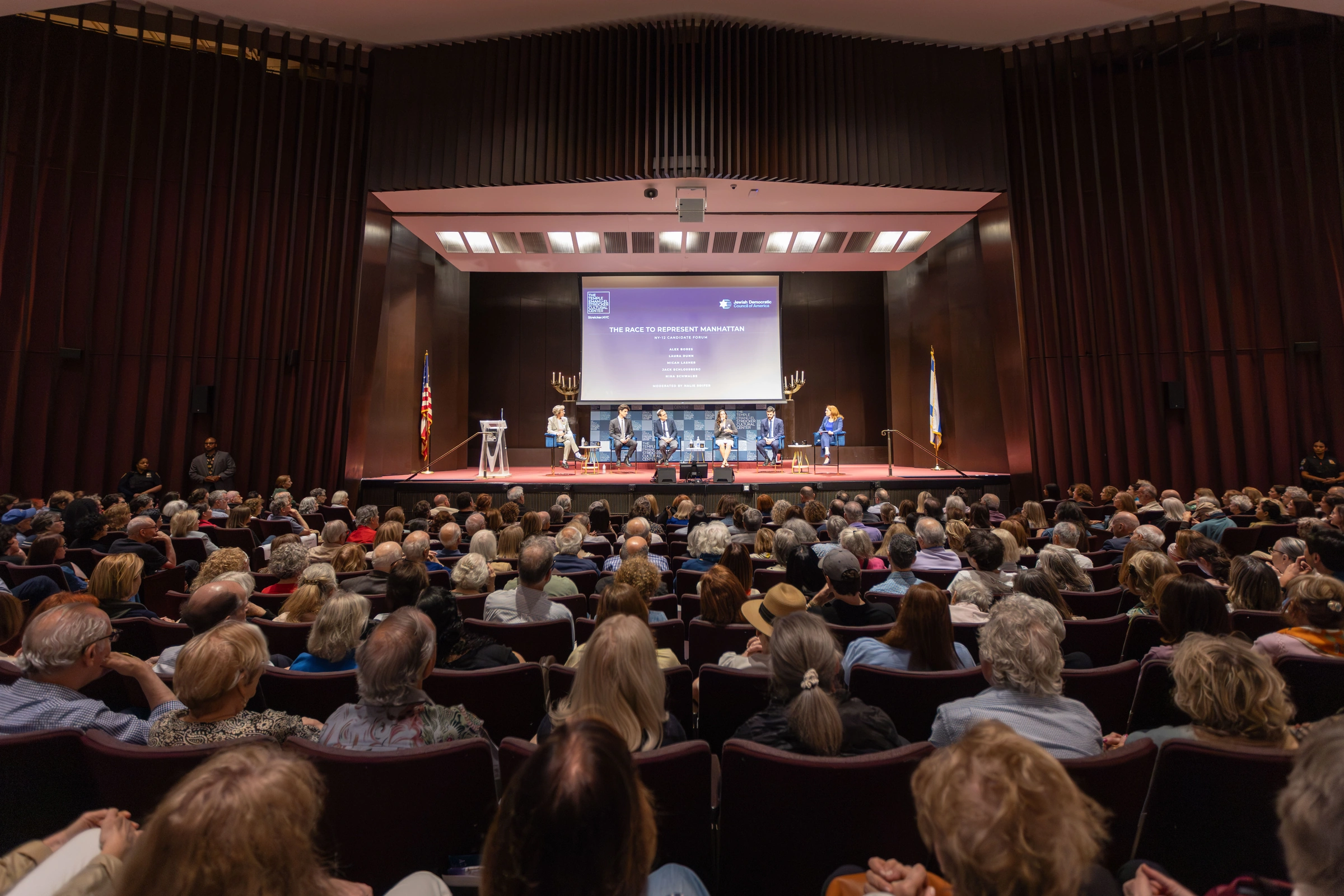 A wide view of the audience and panel at the NY-12 candidate forum