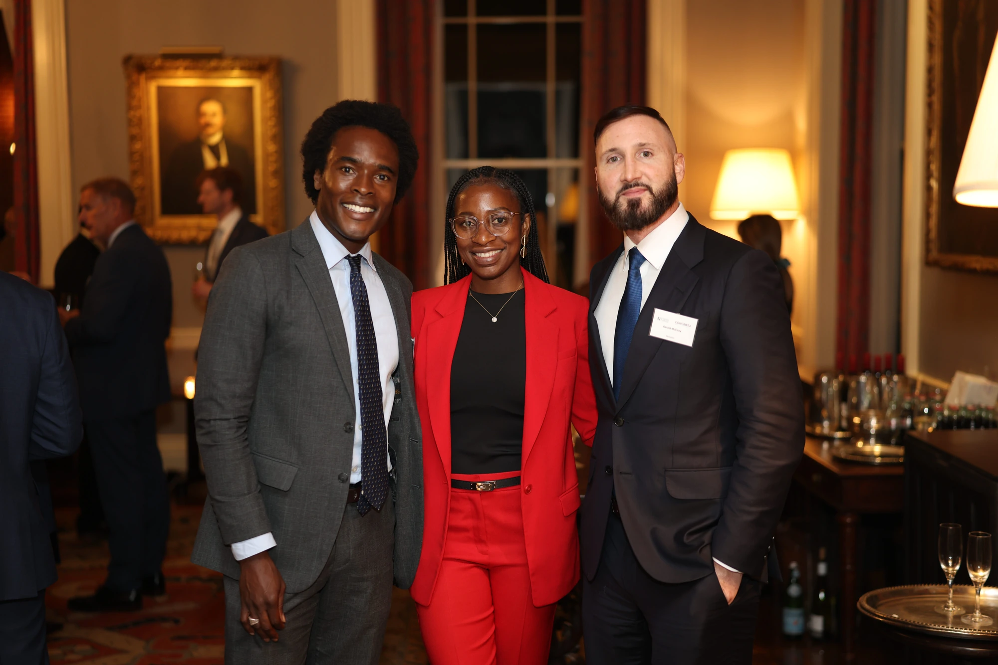 Three guests posing together at an evening reception