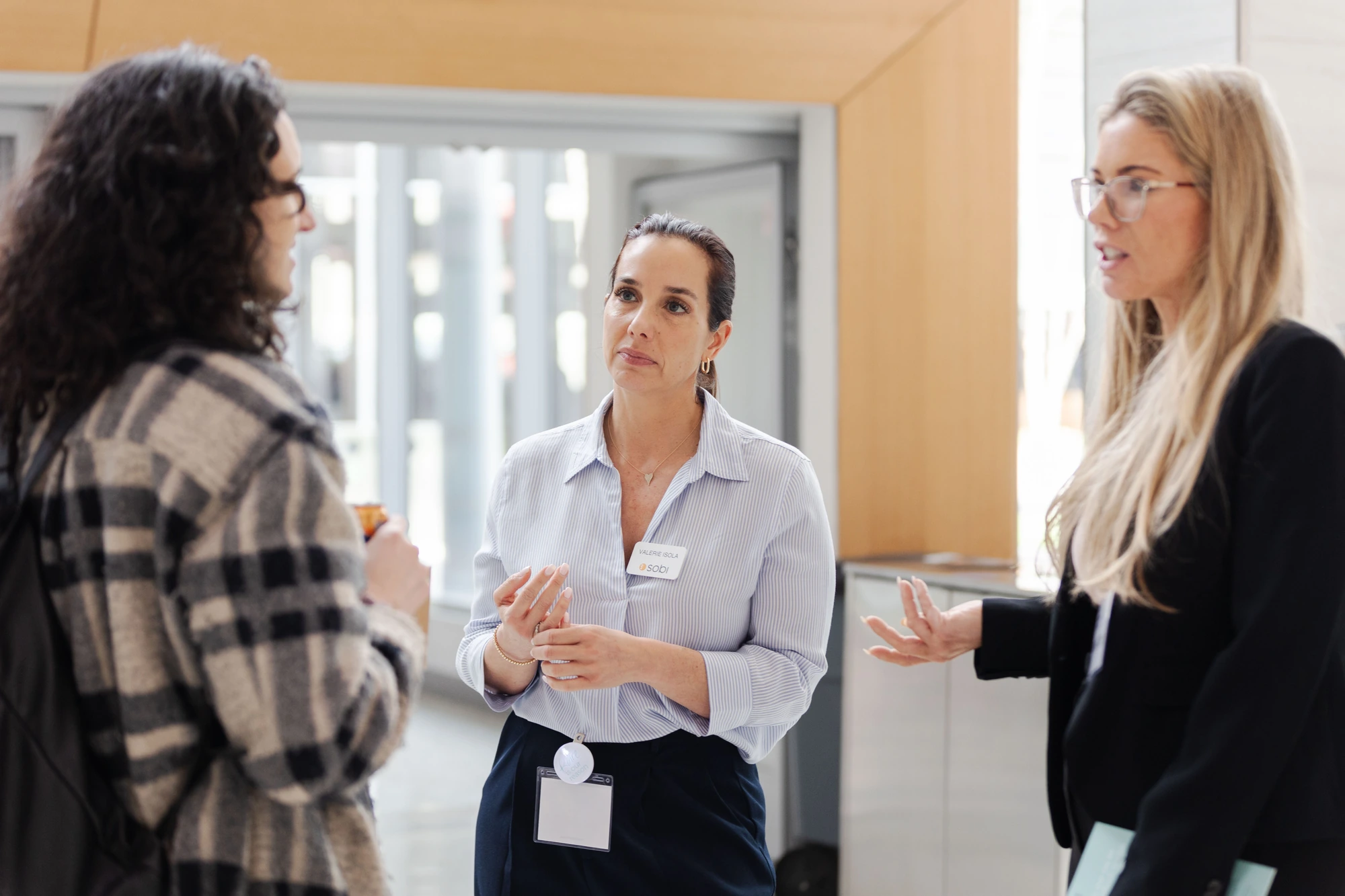 Attendees in conversation at a professional daytime event