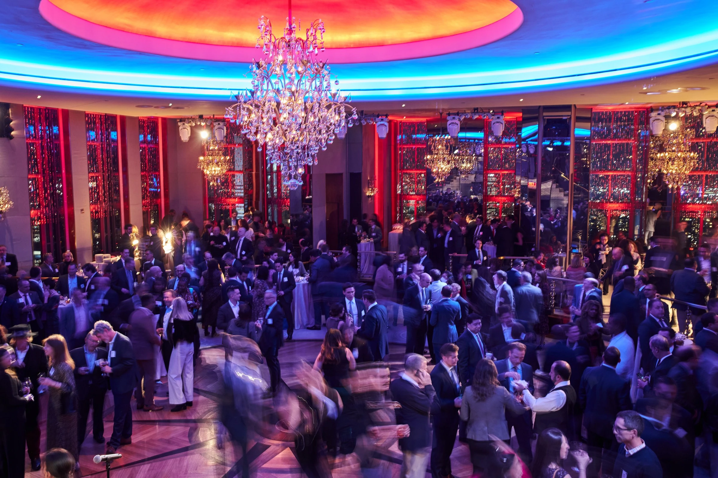 The illuminated Rainbow Room with a chandelier and guests at an evening reception