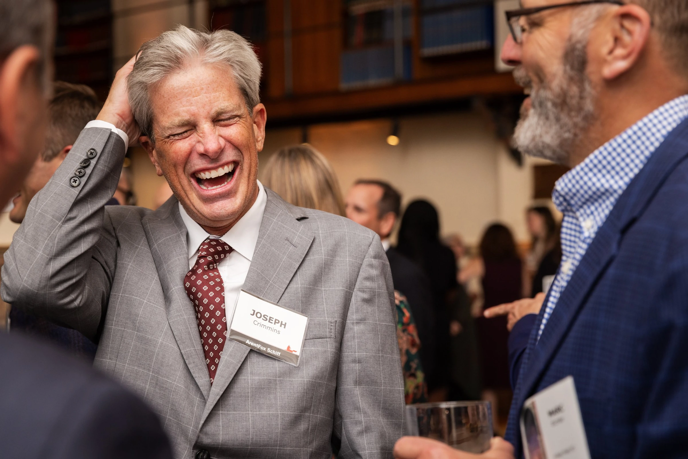 A guest laughing during a lively conversation at a reception
