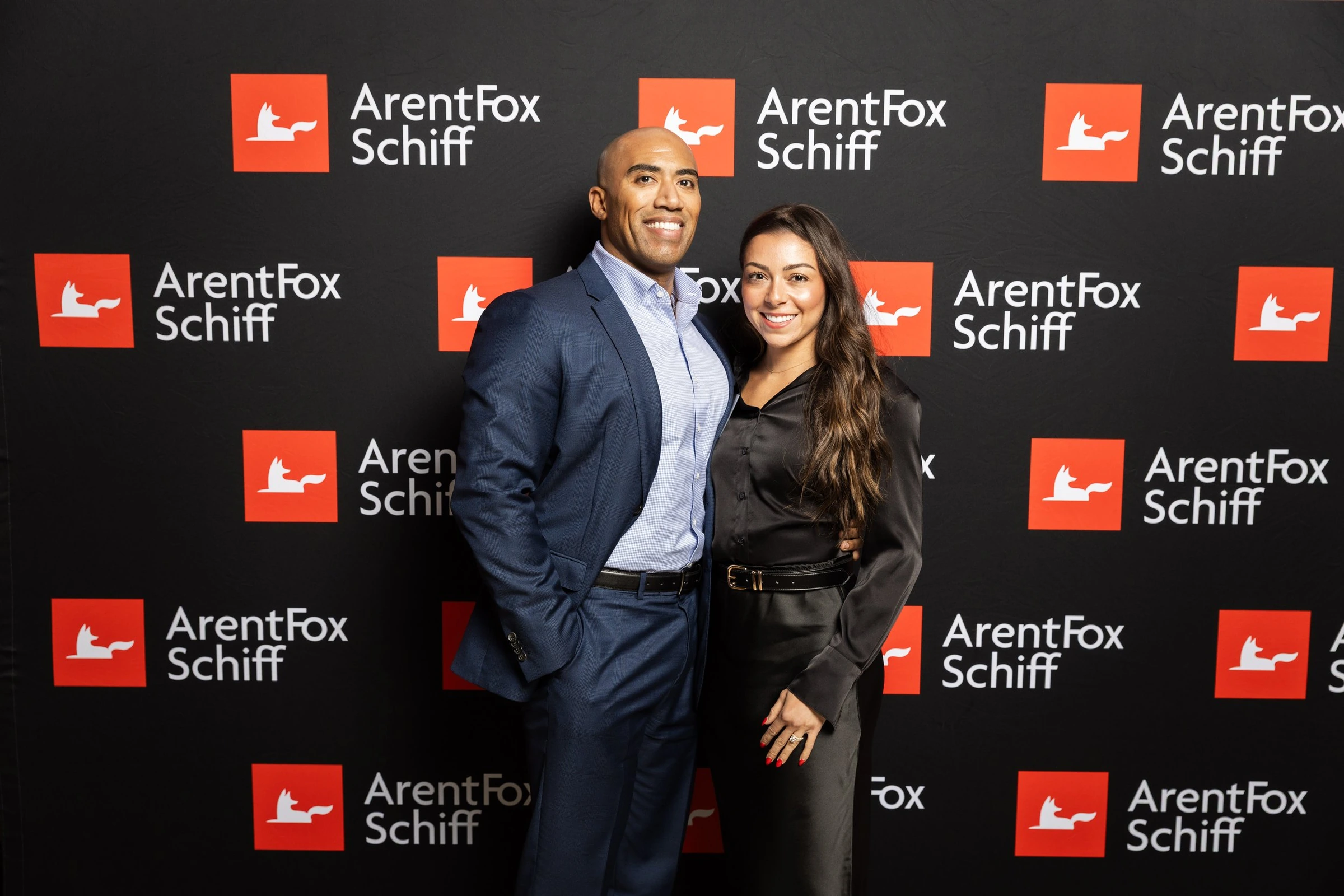 Two guests at the ArentFox Schiff event backdrop