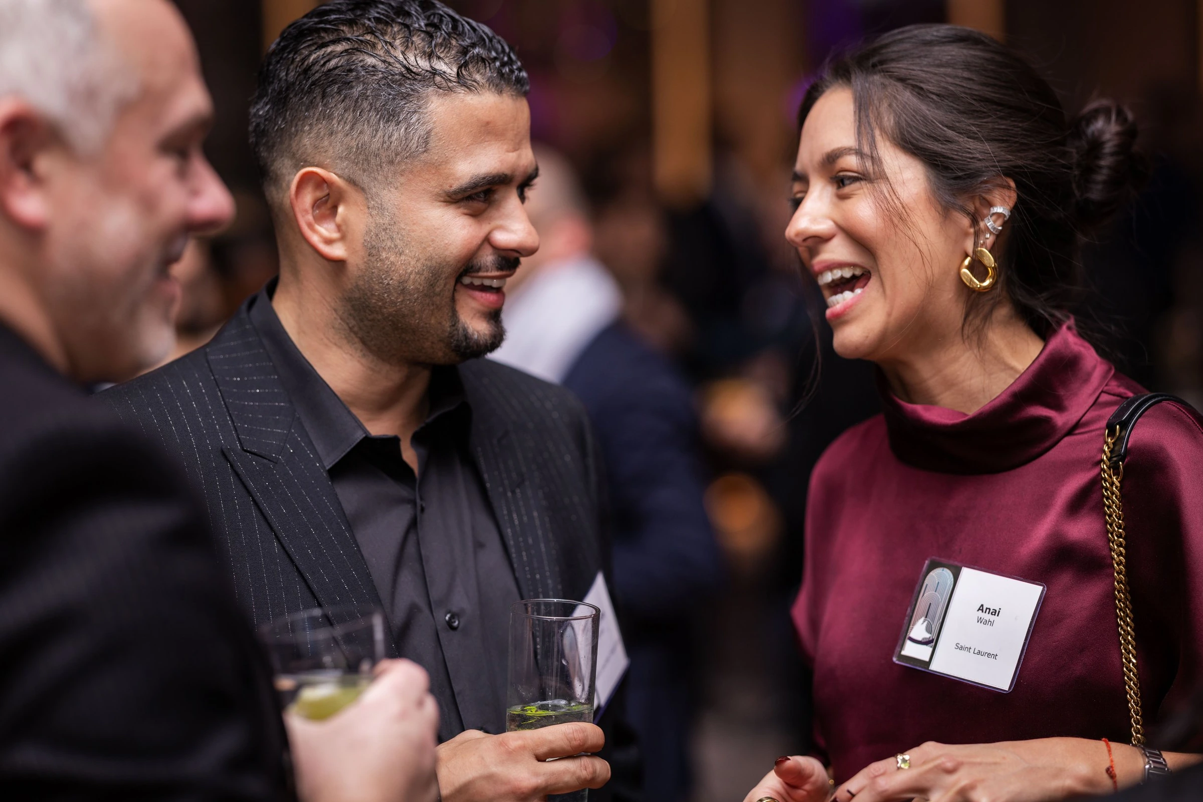 Two guests laughing together during a company reception