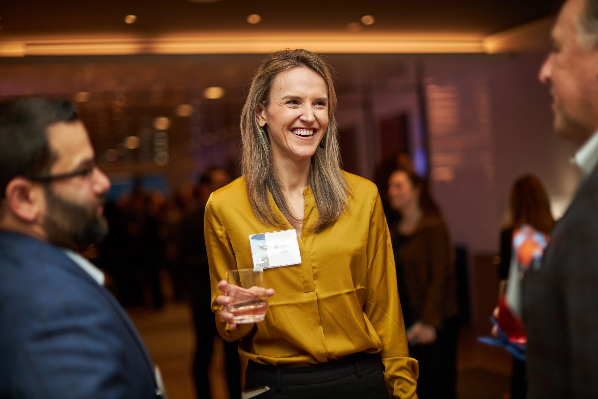 A guest in a yellow blouse at an evening reception