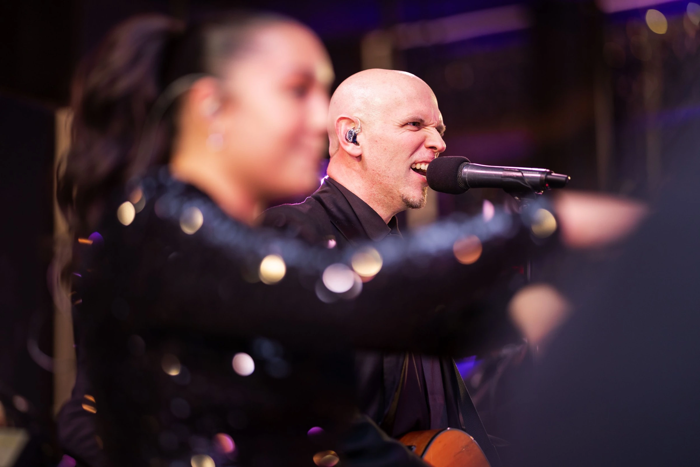 A singer performing with a microphone during an evening event