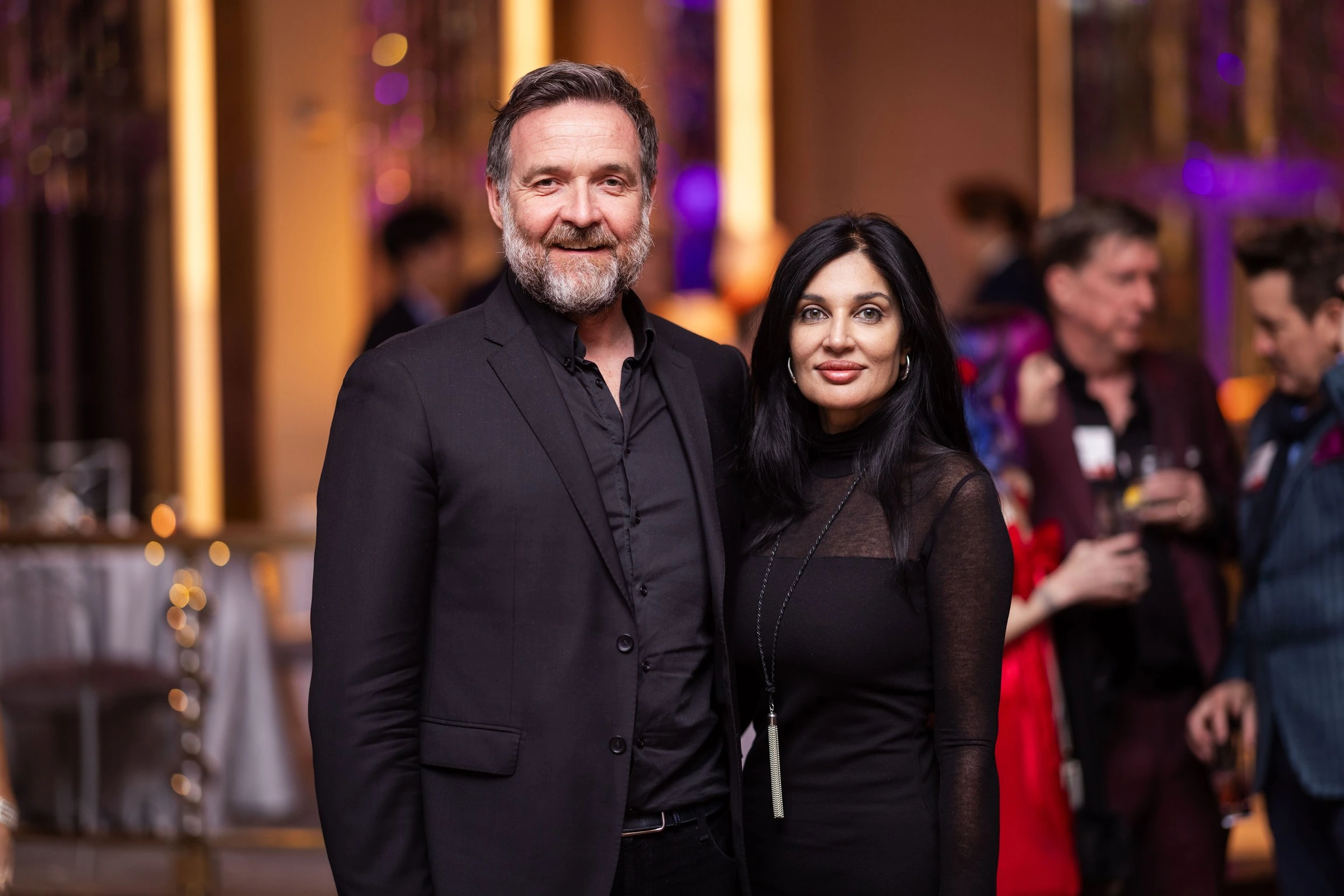 Two guests posing together at an evening celebration