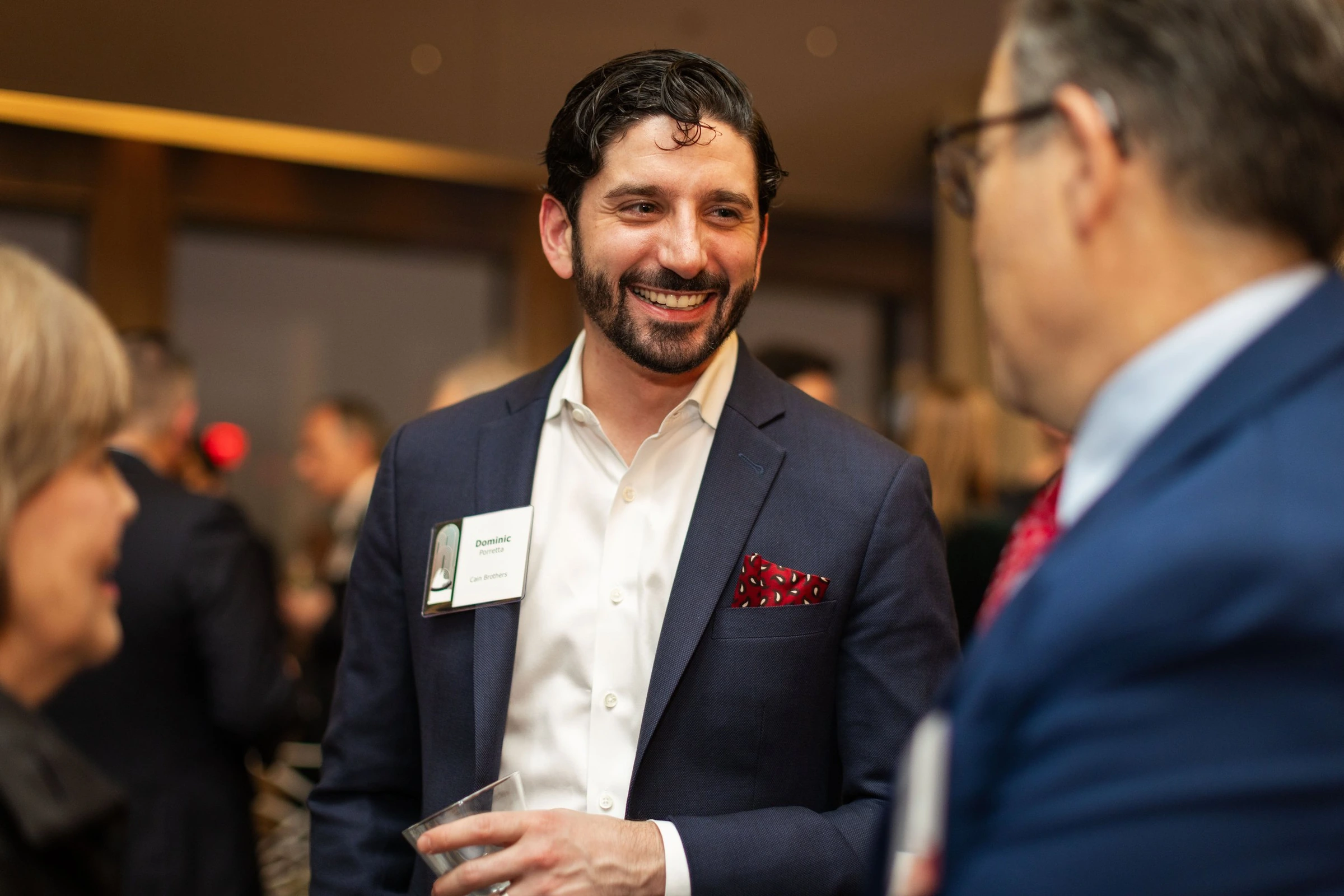 A guest smiling during a conversation with a colleague