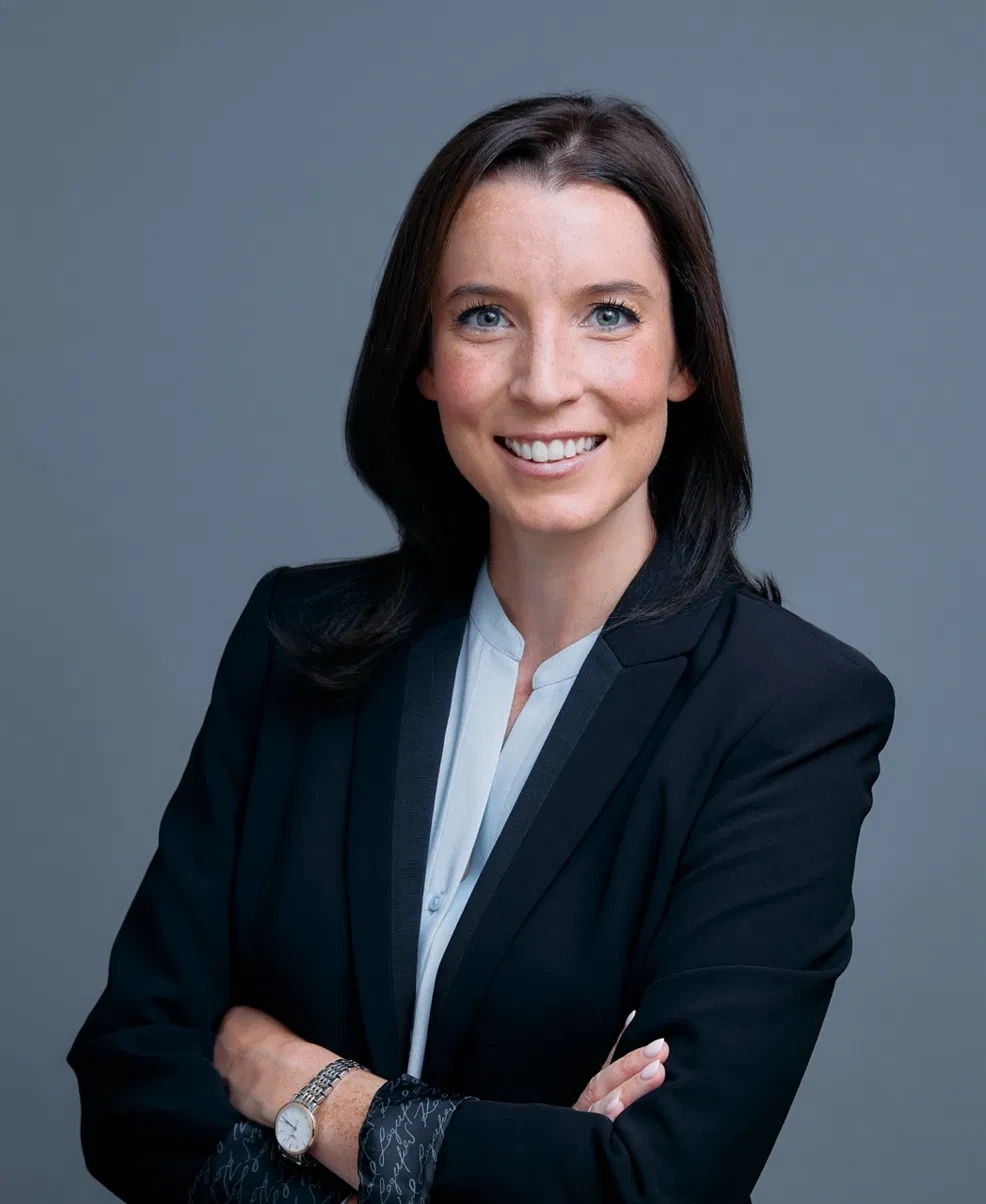 Professional portrait in a navy blazer with arms crossed