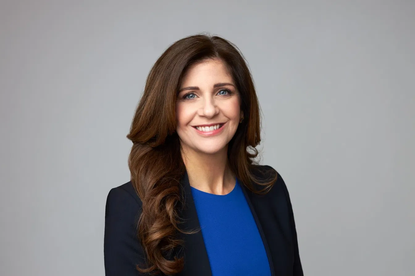 Professional portrait in a black blazer and blue top