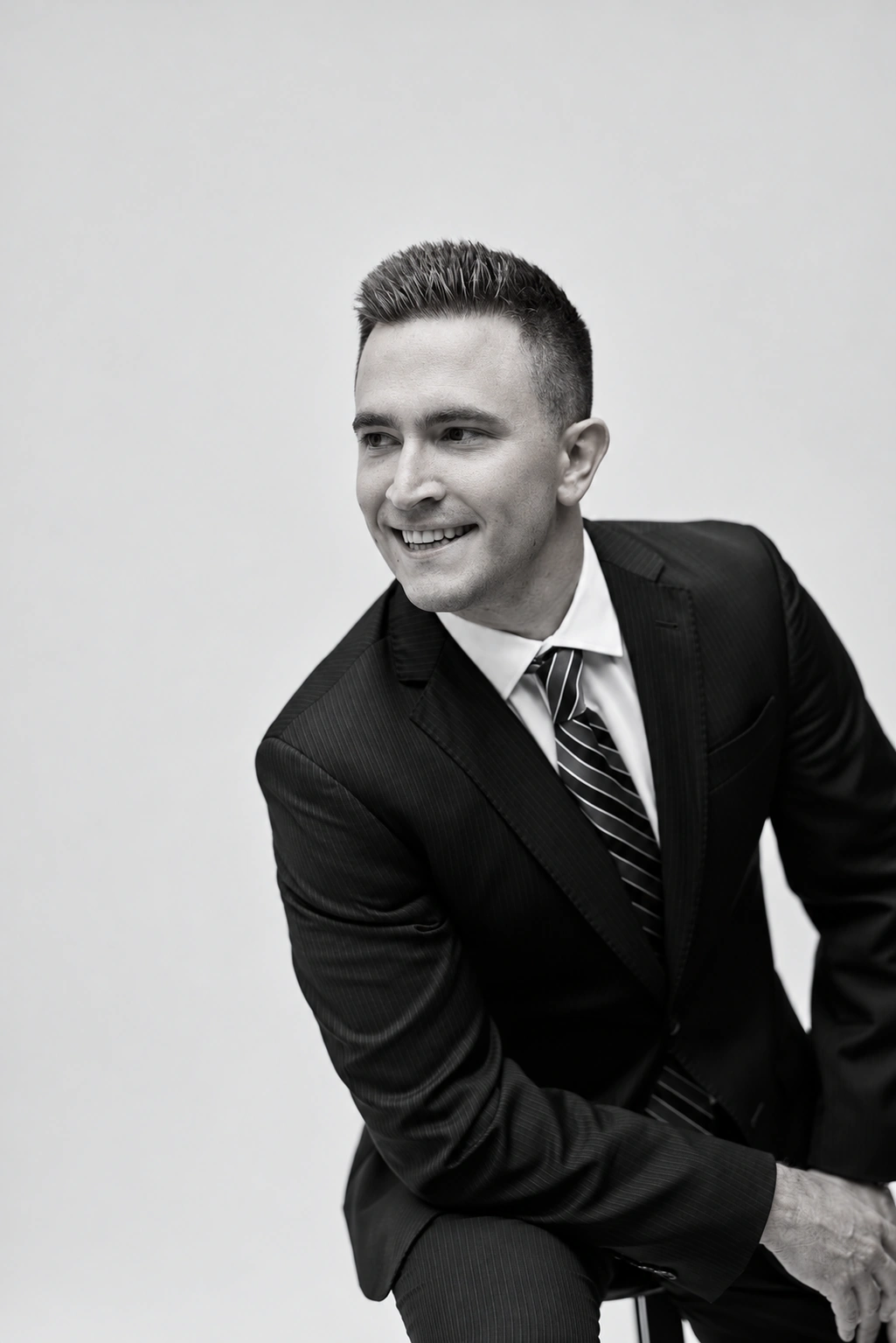 Black-and-white seated executive portrait looking off-camera